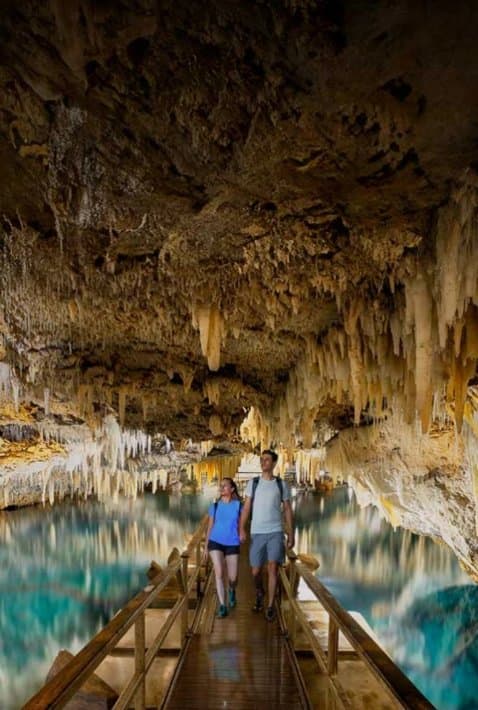 Couple walking a boardwalk through a cave in Bermuda